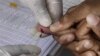 In this November 2010 file photo, a patient undergoes a pin-prick blood test inside a mobile healthcare clinic parked in downtown Johannesburg. 