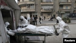 Kelompok medis dari Tentara Pembebasan Suriah melatih orang-orang mengatasi serangan senjata kimia di Aleppo, Desember 2013.