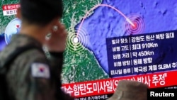 A South Korean soldier walks past a TV broadcasting a news report on North Korea firing a missile that is believed to be launched from a submarine, in Seoul, South Korea, Oct. 2, 2019. 