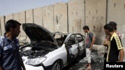 Warga Baghdad memeriksa lokasi ledakan di distrik Kazimiyah, Baghdad hari Sabtu (16/6). Serangan atas peziarah Syiah ini menewaskan 26 orang setelah serangan sebelumnya hari Rabu menewaskan 72 orang. 