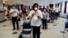 FILE - Immigrants pick flags as they arrive to take their citizenship oath during naturalization ceremonies at a U.S. Citizenship and Immigration Services (USCIS) ceremony in Los Angeles, Sept. 20, 2017.
