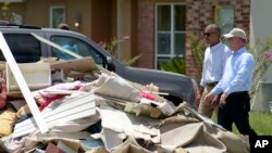 바락 오바마(왼쪽) 대통령이 23일 루이지애나 홍수피해 지역을 방문, 존 벨 에드워즈 주지사와 함께 배턴루지 일대 주택가를 둘러보고 있다. 