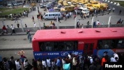 Warga antre naik bus di distrik Obalende di Lagos, Nigeria, tempat ojek dilarang beroperasi di pusat-pusat kota. (Reuters/Akintunde Akinleye)
