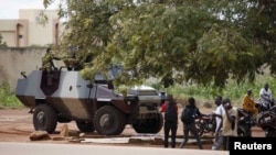 Des éléments du Régiment de la sécurité présidentielle chargent des civils et des journalistes près d'un véhicule blindé de l'armée non loin de l'hôtel Laico à Ouagadougou, Burkina Faso