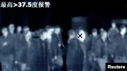 Temperatures of travelers are monitored by thermal scanner to fevers and other symptoms at train station in Beijing, file photo.