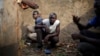 Men take cover in a toilet as heavy gunfire erupts in the Miskin district of Bangui, Central African Republic, Monday Feb. 3, 2014. In what a French soldier on the scene described as the heaviest exchange of fire he'd seen since early December 2013, Musli