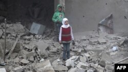 지난 22일 시리아 반군 점령 지역인 동구타 하무리아에서 정부군의 계속된 폭격으로 폐허가 된 건물 잔해 사이에 어린이들이 서 있다.