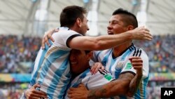 Lionel Messi (kiri) merayakan gol Argentina dengan pencetak gol Angel Di Maria dan Marcos Rojo di São Paulo, Selasa (1/7).