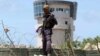 A policeman stands guard near the air-control tower of a airport following a suicide bombing near the African Union's main peacekeeping base in Mogadishu, Somalia, July 26, 2016. 