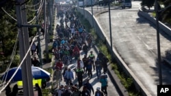 2018年11月9日，一群中美洲移民离开墨西哥城的耶稣马丁内斯体育场临时避难所后重新踏上了他们的旅程。