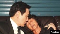 台湾总统马英九(左)2013年5月12日前往屏东县小琉球的一个于上个星期被菲律宾海岸警卫队枪杀的台湾渔民洪石成的家中安慰受害者的遗孀