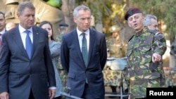 Le colonel Daniel Cristian Dan, de l'armée roumaine, guide le secrétaire général de l'OTAN, Jens Stoltenberg, et le président roumain Klaus Iohannis lors de leur visite à la brigade multinationale de l'OTAN à Craiova, Roumanie, 9 octobre 2017.