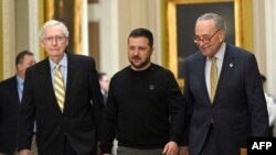 乌克兰总统弗拉基米尔·泽连斯基（中）在美国参议院多数党领袖查克·舒默（右）和少数党领袖米奇·麦康奈尔（左）的陪同下，于 12 月抵达华盛顿特区国会山会见美国参议院议员2023 年 12 日。