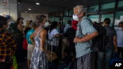 Travelers wait for a charter flight coordinated by the U.S. embassy at the La Aurora airport in Guatemala City, March 24, 2020.