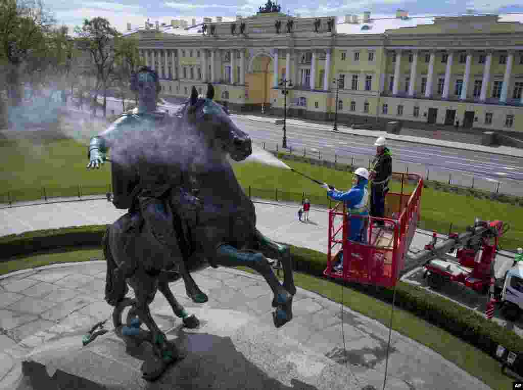 A worker washes a city landmarks, the equestrian statue of Peter the Great known as the Bronze Horseman by French sculptor Etienne Maurice Falconet, in St.Petersburg, Russia.