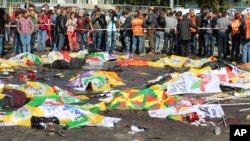 Des corps des victimes sont recouverts avec des drapeaux à Ankara, en Turquie, le 10 octobre 2015. (AP Photo/Burhan Ozbilici)