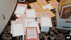 ແຟ້ມ - ຮູບ​ໃນ​ສຳ​ນວນ​ຟ້ອງ ໂດຍ​ກະ​ຊວງ​ຍຸ​ຕິ​ທຳ ເມື່ອ​ວັນ​ທີ 30 ສິງ​ຫາ 2022 ທີ່​ມີ​ການ​ລຶບ​ແຫຼ່ງ​ຂ່​າວ​ອອກ​ເປັນ​ບາງ​ສ​່ວນ ສະ​ແດງ​ໃຫ້​ເຫັນ​​ຮູບເອກ​ກະ​ສານ ທີ່​ຢຶດ​ໄດ້​ເມື່ອ​ວັນ​ທີ 8 ສິ​ງ​ຫາ ຈາກ​ການ​ຄົ້ນ​ບ້ານ​ພັກ​ ມາ​ອາ​ລາ​ໂກ ຂອງ​ອະ​ດີດ​ປະ​ທາ​ນາ​ທິ​ບໍ​ດີ​ດໍ​ໂນ​ລ ທ​ຣຳ ໂດຍ​ອົງ​ການ​ FBI.