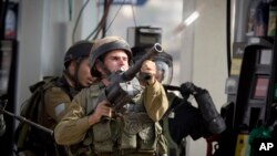 12일 요르단 서안지구 라말라흐 인근에서 이스라엘 군이 팔레스타인 시위대를 향해 최루가스를 쏘고 있다.