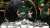 FILE - A member of the Philippine Drug Enforcement Agency, PDEA, collects packs of Methamphetamine Hydrochloride also known as "Shabu" which they found hidden inside a steel cylinder in one of the biggest drug hauls in Manila, Philippines, on Aug. 7, 2018. 
