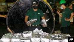 FILE - A member of the Philippine Drug Enforcement Agency, PDEA, collects packs of Methamphetamine Hydrochloride also known as "Shabu" which they found hidden inside a steel cylinder in one of the biggest drug hauls in Manila, Philippines, on Aug. 7, 2018. 