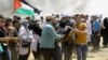Palestinian protesters evacuate a wounded youth near the Israeli border fence, east of Khan Younis, in the Gaza Strip, May 14, 2018. 