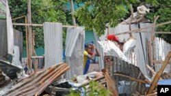 FILE - A man peers though the remains of destroyed houses after a suicide bomb attack in Mogadishu, Somalia, Nov. 17, 2020. 