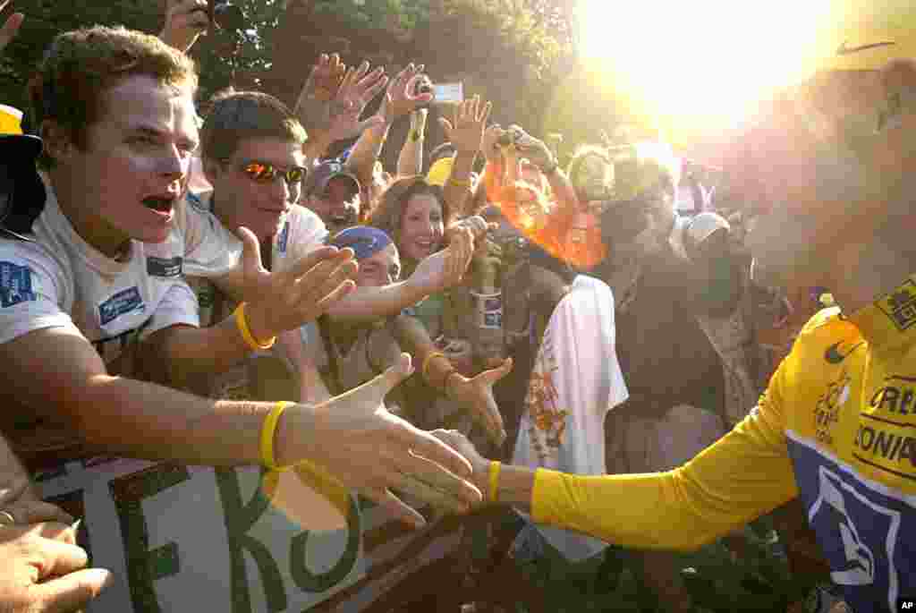 July 25, 2004: Armstrong greets fans after the race on the Champs Elysees avenue in Paris.