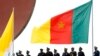 FILE - Cameroonian police stand near a national flag.