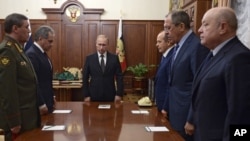 17일 러시아 모스크바 크렘린 궁에서 열린 여객기 추락 사건 관련 회의에 앞서, 블라디미르 푸틴 러시아 대통령(가운데)과 알렉산드르 보르트니코프 연방안보국(FSB) 국장(왼쪽 세번째), 세르게이 라브로프 러시아 외무장관(오른쪽 두번째) 등 각료들이 묵념의 시간을 가지고 있다.