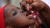 FILE - An unidentified health official administers a polio vaccine to a child in Kawo Kano, Nigeria.