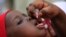 FILE - An unidentified health official administers a polio vaccine to a child in Kawo Kano, Nigeria, April. 13, 2014.