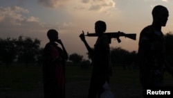 Un homme armé et une femme de la tribut de Luo Nuer discutent dans l'état de Yuai Uror, Soudan du Sud, 24 juillet 2013. 