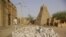 Men work alongside one of Timburktu's historic mud mosques, in Timbuktu, Mali. (file photo)