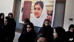 Anak-anak perempuan Pakistan berada di sekolah dengan poster teman sekelas mereka yang ditembak militan Taliban, Malala Yousafzai di sekolah Khushal kota Mingora, Lembah Swat, Pakistan (foto: dok). 