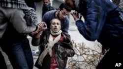 13일 시리아 알레포 인근 사이프 알다왈라에서 박격포 공격으로 부상을 입은 주민을 주변 사람들이 돕고 있다.