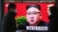 People walk by a TV screen showing North Korean leader Kim Jong Un during a ruling party congress, at the Seoul Railway Station in Seoul, South Korea, Jan. 6, 2021. 