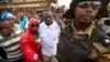 Ugandan opposition leader and presidential candidate Kizza Besigye, center, is detained by riot police after attempting to walk with his supporters along a street in downtown Kampala, Feb. 15, 2016.