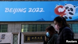 资料照：人们走过北京冬奥会的宣传标语。