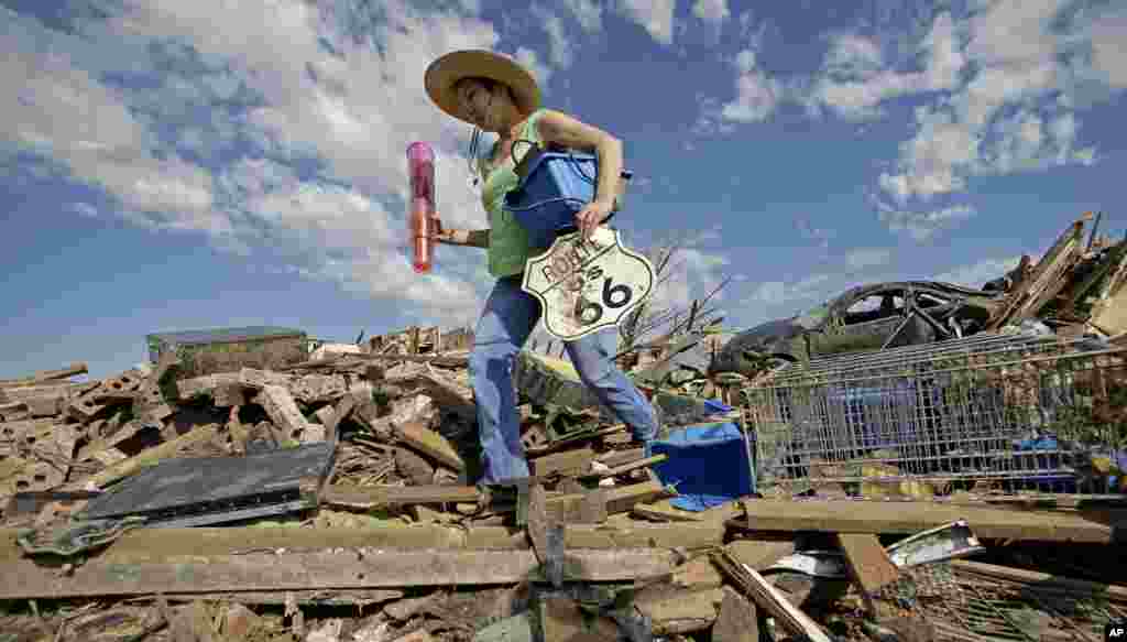 Susan Kates menyelamatkan barang-barang dari rumah temannya yang hancur karena tornado di Moore, Oklahoma (22/5). (AP/Charlie Riedel)