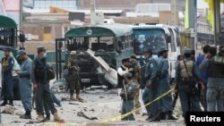 30일 아프가니스탄 수도 카불에서 보안요원들이 탈레반 자살 폭탄 테러 현장을 조사하고 있다. 탈레반이 경찰 버스를 공격해 30여명이 숨졌다.