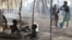 Children sit outside their family's tent as a neighbor bathes her son in a camp housing more than 2,600 Ivorian refugees in Solo Town, near Zwedrou, Liberia, May 25, 2011 (file photo).