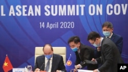 Vietnamese Prime Minister Nguyen Xuan Phuc, left, and his staff prepare documents ahead of the Special ASEAN summit on COVID-19 in Hanoi, Vietnam Tuesday, April 14, 2020. ASEAN leaders and their counterparts from China, Japan and South Korea hold…