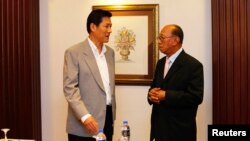Secretary-General of Thailand's National Security Council Paradorn Pattanathabutr (L) speaks to Chairman of the Advisory Council for Peace Building in the Southern Border Provinces Aziz Benhawan, at a hotel in Kuala Lumpur, Mar. 28, 2013. 