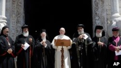Pope Francis, center, flanked by Ecumenical Patriarch Bartholomew, left, Teodoro II, right, and other Orthodox patriarchs and Catholic leaders, reads his message outside the St. Nicholas Basilica on the occasion of a daylong prayer for peace in the Middle East in Bari, southern Italy, Saturday, July 7, 2018.