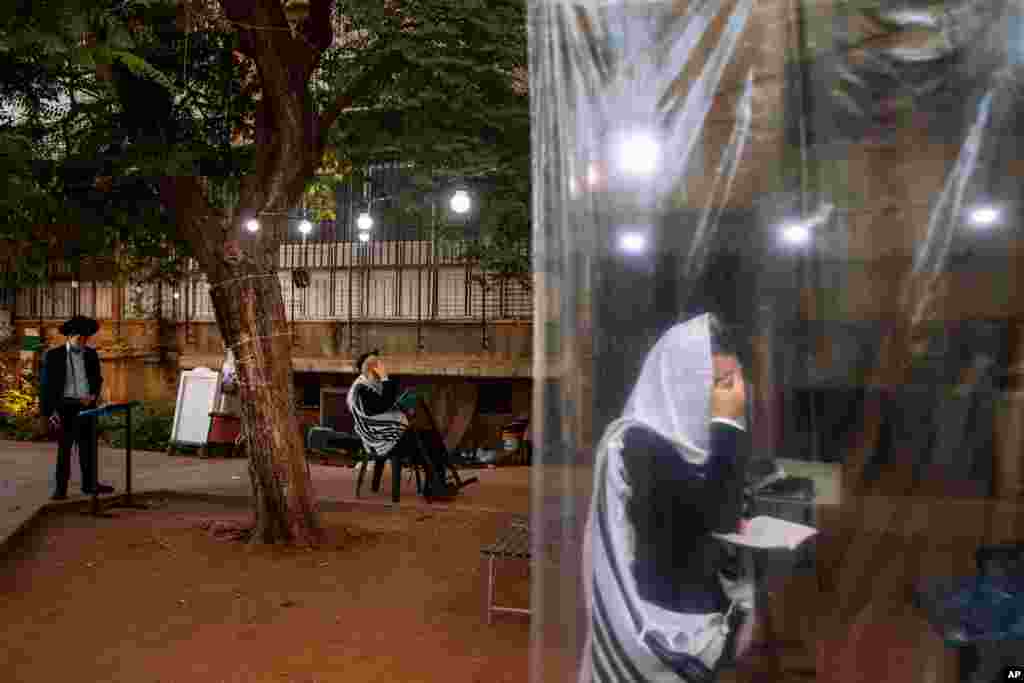 이스라엘 브네이브락(Bnei Brak)의 초정통파 유대교 신자가 신종 코로나바이러스 방지 칸막이 안에서 아침 기도를 드리고 있다. 