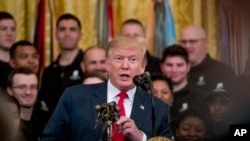 FILE - President Donald Trump holds a statue of the Wounded Warrior Project logo as he speaks at a Wounded Warrior Project Soldier Ride event in the East Room of the White House, in Washington, April 18, 2019.