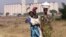 Malawian women walk past empty grain silos in the capital Lilongwe.