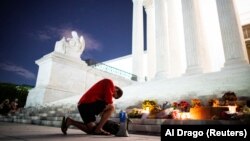 Homem ajoelha-se em respeito a RBG em frente ao Supremo Tribunal em Washington