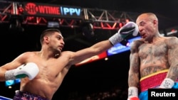 Amir Khan (L) of Britain punches Luis Collazo of the U.S. during their fight in Las Vegas, Nevada, May 3, 2014. (FILE) 