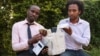Makerere University Telecom graduates Brian Turyabagye (left) and Besufekad Shifferaw (Right) show off the smart jacket that will be used in the diagnosis of pneumonia in children, Kampala, Uganda, April 5, 2017. (H. Althumani/VOA)